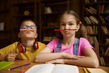 Portrait of cute children holding pencil on mouth under nose