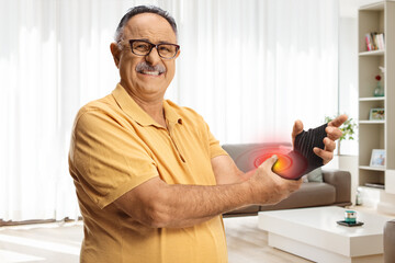 Mature man in pain wearing an elastic wrist bandage