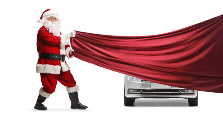 Santa Claus pulling a red piece of cloth in front of a new car - obrazy, fototapety, plakaty