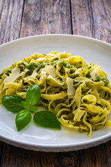 Tagliatelle with basil pesto sauce on wooden table
