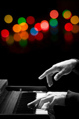 closeup male pianist hands playing piano with colorful bokeh. music background
