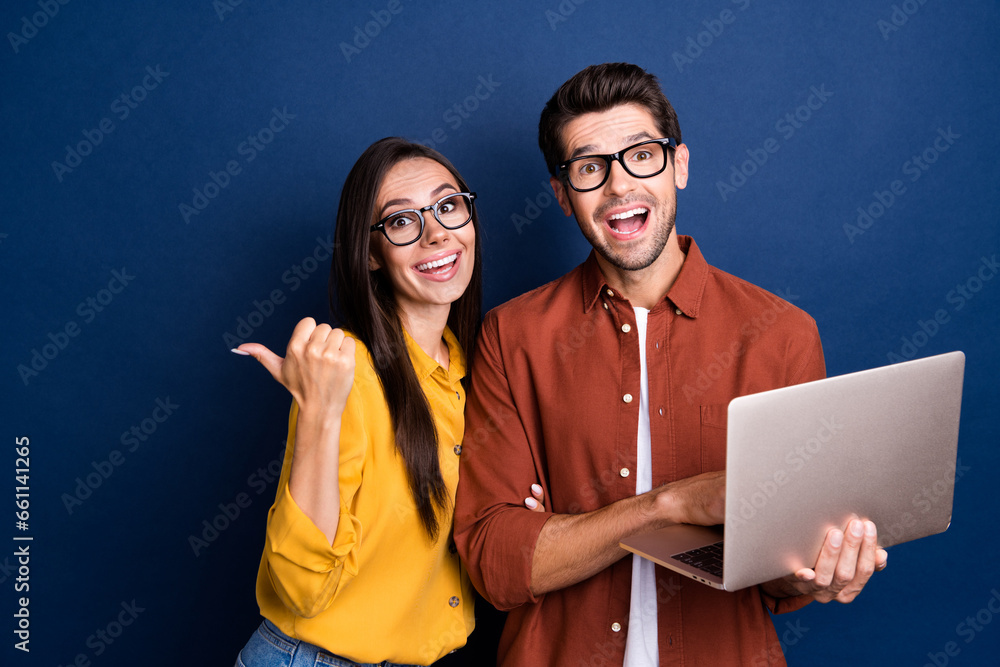 Poster portrait of two astonished crazy people use netbook direct finger empty space information isolated o