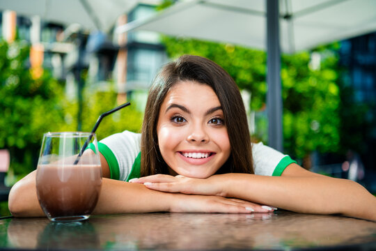 Photo of lovely cute cheerful girl dressed trendy clothes enjoying morning breakfast in cafe drinking tasty tea outdoors
