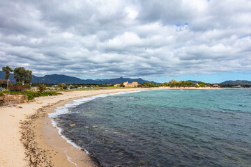 beach, visible church in the background, Chiesa Romanica di Sant'Efisio - Nora, old church located on the seashore, Sardinia, Italy