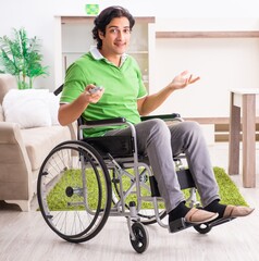 Obraz premium Young handsome man in wheelchair at home
