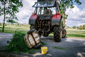 An overturned trailer lies next to a tractor, illustrating an unfortunate incident or accident on...
