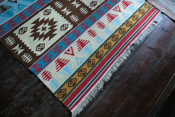 Detail of a handcrafted Turkish Carpet on the rustic wooden floor