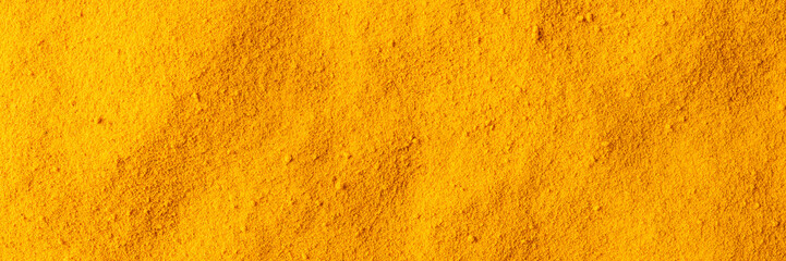 Turmeric powder texture. Background with copyspace. Close up. Top view