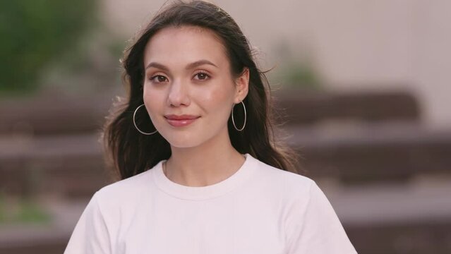 Shy and happy pretty gen z teenage girl smiling and looking at camera.