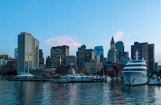 A view of Boston, boats, and a large yacht from a boat in Boston Harbor