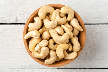 Fresh cashews in bowl on white wooden table. Healthy snacks