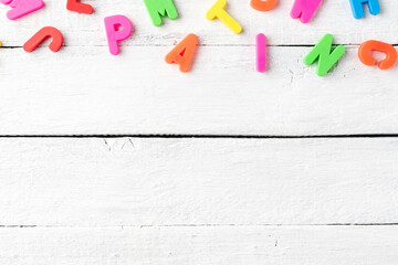 Colourful letters on white wooden background. School concept