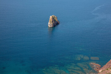 lone boulder sticks out of the sea