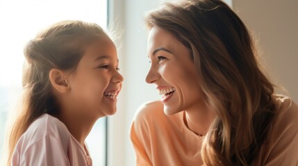 Naklejka premium Mother and little girl looking at each other and laughing