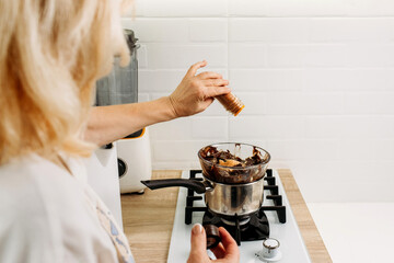 The confectioner pours dry ground paprika into the melted chocolate.