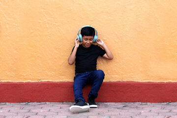 Brown Latino 9 year old boy with anti noise headphones for children with asperger syndrome, autism...