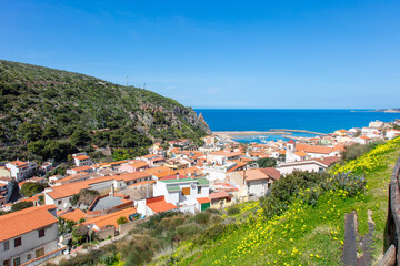 Fototapeta na wymiar view from the top of the hill onto a beautiful and picturesque town Buggerru, Sardinia, Italy lying on the seashore of Mediterranean sea