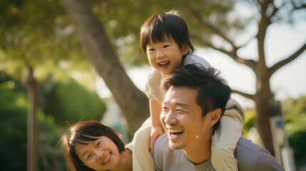 Happy pose of an Asian family in the park among the greenery - obrazy, fototapety, plakaty