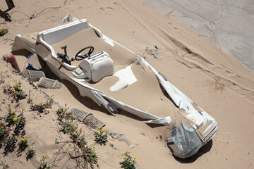 abandoned motorboat completely covered with beach sand