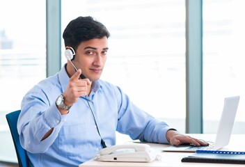 Male call-center operator in business concept