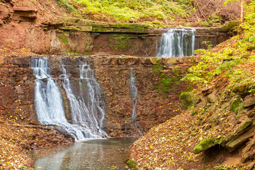 Beautiful cascade of several waterfalls in a mountain stream in the forest. Rusyliv waterfalls. Rusyli, Ternopil region, Ukraine