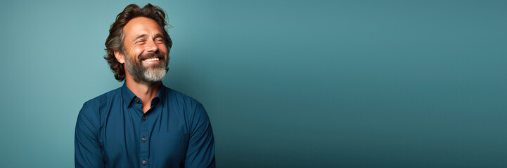 middle age man wearing a blue shirt looking to the side smiling in against a green background. Banner design with space for text