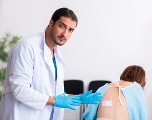 Injured young woman visiting young male doctor