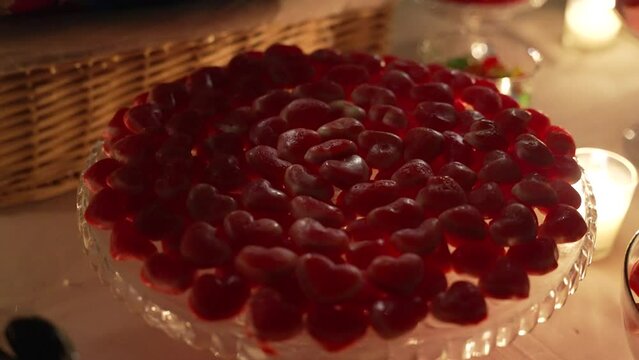 Chucher&iacute;as con forma de coraz&oacute;n por la noche a la luz de una vela encima de una mesa en una boda