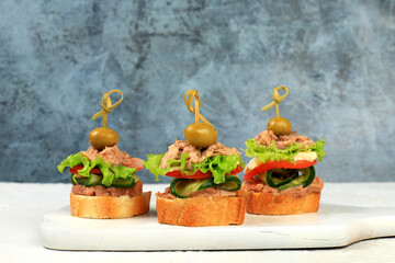 A set of snacks for the holiday table. Canapes of tomatoes, pate, tuna,cucumbers, olives and salad on an old table, vegan food concept, menu and advertising for a cafe, Christmas and New Year dishes