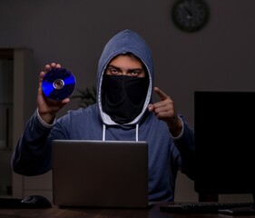 Male hacker hacking security firewall late in office