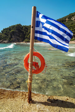 Greek flag with life belt, Ionian seashore near Sinarades town on Corfu Island, Greece