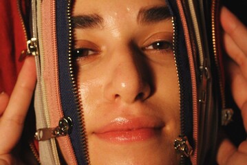 closeup portrait of woman being unzipped through zips