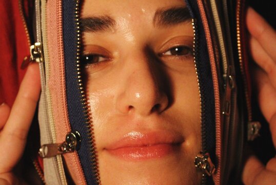 closeup portrait of woman being unzipped through zips