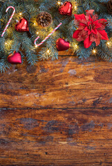 A festive Christmas garland featuring vibrant poinsettia flower beautifully displayed on a rustic wooden backdrop - 661176675