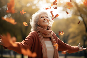 Senior woman with arms outstretched enjoying nature in park. High quality photo - obrazy, fototapety, plakaty