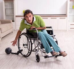 Young male invalid in wheel-chair suffering at home