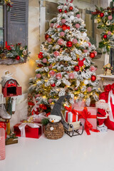 Christmas decorations in red and gold colors. Beautiful holiday decorated room with Christmas tree with presents under it,Santa Claus toy, toy snowman. New Year's holiday card.