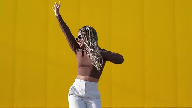 young beautiful  woman dancing on a yellow background