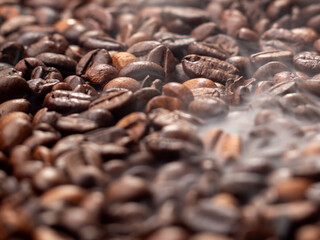 Close-up of roasted coffee beans with smoke. Coffee beans in smoke.