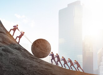 Teamwork example with business people pushing stone to top - obrazy, fototapety, plakaty