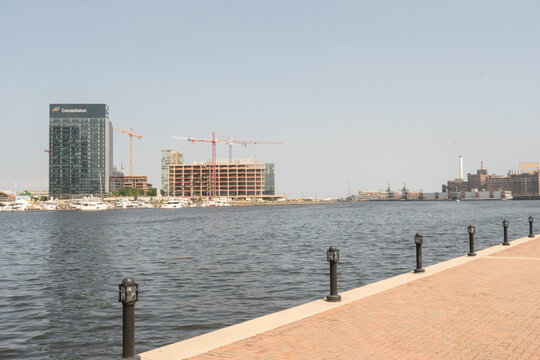 Baltimore, MD US - July 26, 2023: Construction cranes on the Harbor East peninsula, seen from the waterfront promenade walk, across the inner harbor.