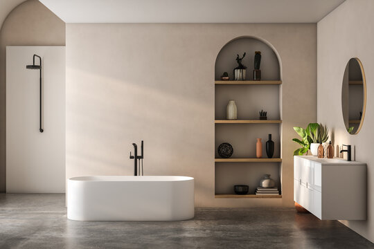 Modern bathroom interior with beige and white walls, shower area, basin with mirror, shelf and grey concrete floor.