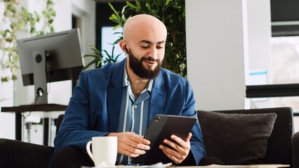 Manager attends briefing meeting on tablet, using videocall to share new ideas about programming software. Small business analyst working on online conference to increase profit. Handheld shot. © DC Studio