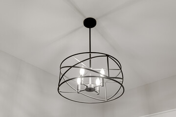 Round Metal Farmhouse Modern Light Fixture with Black Rod and Empty Clean White Ceiling