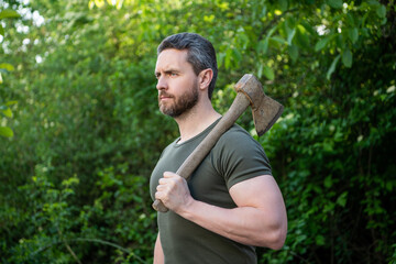 Naklejka na ściany i meble image of man with axe. man with axe. man with axe wearing shirt. man with axe outdoor