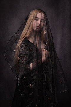 classic renaissance portrait of blonde girl with black veil embracing herself