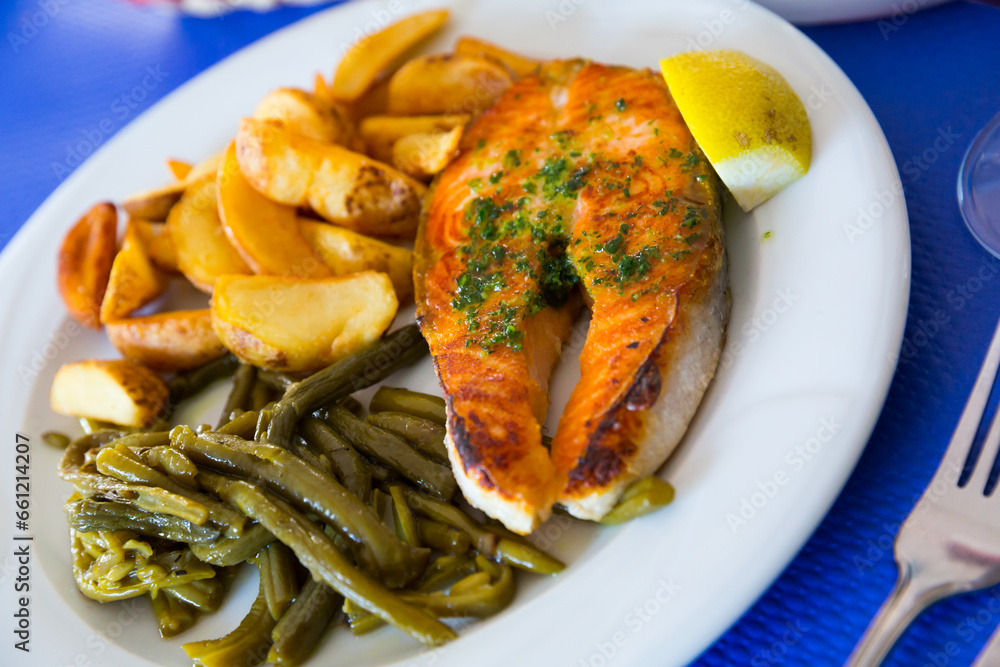 Wall mural Fried salmon fillet served with baked potatoes and green beans