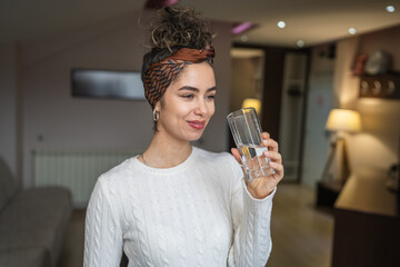 portrait of woman young caucasian female drink glass of water at home