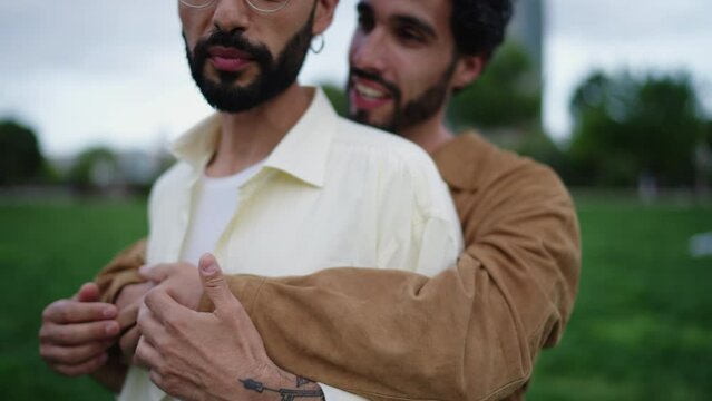 Couple of gay guys in love are standing in embrace, male lgbt couple talking carefree about something, feeling each other's touch. Gay men are happy and in love with each other. Homosexual identity