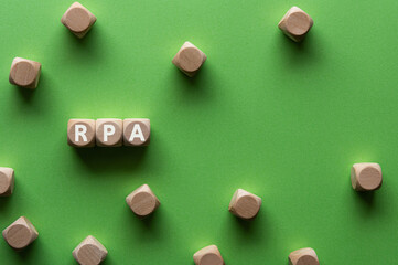 There is wood cube with the word RPA. It is an abbreviation for Robotic Process Automation as eye-catching image.